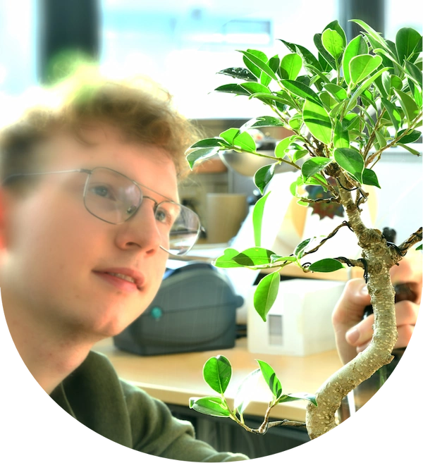 tom op kantoor bij Van Doren Reclame met een bonsai boompje